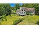 Back exterior of home with large deck, lawn and mature trees at 3909 Laurens Ln, Snellville, GA 30039