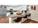 Open kitchen with stainless steel appliances, white cabinets, granite countertops, and breakfast bar at 3909 Laurens Ln, Snellville, GA 30039