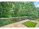 This wooden back deck with green turf overlooks a yard with mature landscaping at 4000 Mcpherson Drive, Acworth, GA 30101