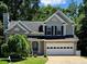 Two-story home featuring a brick and vinyl exterior, attached two-car garage, and mature landscaping at 4000 Mcpherson Drive, Acworth, GA 30101