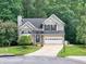 Charming two-story home featuring brick accents, a well-manicured lawn, and a driveway leading to an attached garage at 4000 Mcpherson Drive, Acworth, GA 30101