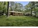 Scenic backyard with mature trees surrounding the home's brick exterior at 4400 Hickory Wood Ln, Atlanta, GA 30360