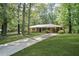 Inviting home with a long driveway and a lush front lawn with mature trees at 4400 Hickory Wood Ln, Atlanta, GA 30360