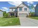 Charming two-story home showcasing a well-manicured lawn, attached two-car garage, and inviting covered front porch at 150 Ivy Chase Loop, Dallas, GA 30157