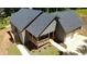 Aerial shot of a charming home with a wooden porch, brick accents, lush green surroundings, and an attached garage at 5950 Lynfield Dr, Atlanta, GA 30349