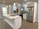 Modern kitchen features a central island, stainless steel appliances, and ample cabinet space, with stylish pendant lighting at 5950 Lynfield Dr, Atlanta, GA 30349