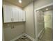 Well-lit laundry room with overhead cabinets and space for washer/dryer hookups and wire shelving unit at 5950 Lynfield Dr, Atlanta, GA 30349