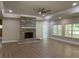 Bright living room featuring a stone fireplace, tray ceiling, recessed lights, and large windows that offer a verdant view at 5950 Lynfield Dr, Atlanta, GA 30349