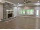 Light-filled living area featuring a large stone fireplace, recessed lighting, and expansive windows overlooking the outdoor scenery at 5950 Lynfield Dr, Atlanta, GA 30349