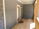 Cozy covered porch with wood flooring, gray siding, and brick accents at 5950 Lynfield Dr, Atlanta, GA 30349