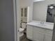 Well-lit bathroom featuring a vanity, toilet, and storage cabinet with a neutral color palette at 115 Davis Mill Ct, Lawrenceville, GA 30044