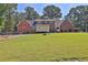 Backyard of home featuring a green lawn, brick exterior, and mature trees at 3765 Cannonwolde Dr, Snellville, GA 30039