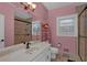 Bright pink bathroom featuring a single sink vanity, walk-in shower, and window at 3765 Cannonwolde Dr, Snellville, GA 30039
