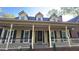 Inviting home featuring a large front porch with detailed columns and charming dormer windows at 3765 Cannonwolde Dr, Snellville, GA 30039