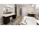 Bathroom featuring a soaking tub, double sinks, tile floors, and a dressing table at 4022 Roberts Crest Dr, Suwanee, GA 30024