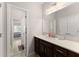 Bathroom featuring a vanity with storage, a framed mirror, and tile floors with a bedroom visible beyond the doorway at 4022 Roberts Crest Dr, Suwanee, GA 30024