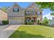 Charming two-story brick home with a well-manicured lawn and inviting front porch at 4022 Roberts Crest Dr, Suwanee, GA 30024