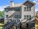 Exterior elevation of the rear of the home with wood deck and stairwell to the yard at 4022 Roberts Crest Dr, Suwanee, GA 30024