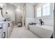 Luxurious bathroom featuring a soaking tub, a double vanity, and modern black fixtures with soft, natural light at 00 Memory Ln, Canton, GA 30115