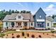 Stunning two-story home featuring a covered porch, meticulous landscaping, and modern farmhouse architectural design at 00 Memory Ln, Canton, GA 30115