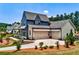 A three-car garage with a connecting driveway framed by a neatly landscaped front yard and a modern farmhouse design at 00 Memory Ln, Canton, GA 30115