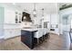 Stylish kitchen with white cabinets, a dark island with seating, and modern pendant lighting above the island at 00 Memory Ln, Canton, GA 30115