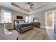 Comfortable bedroom with tray ceilings, hardwood floors, a wooden bed frame, and a view into ensuite bath at 00 Memory Ln, Canton, GA 30115