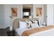 Bedroom featuring neutral tones, stylish lamps, hardwood floors, and an ensuite bathroom entry with eye-catching artwork at 1065 Peachtree Ne St # 3504, Atlanta, GA 30309
