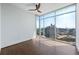 Bright, minimalist bedroom with hardwood floors and expansive windows overlooking the city skyline at 1065 Peachtree Ne St # 3504, Atlanta, GA 30309