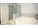 Modern bathroom featuring a glass enclosed shower and soaking tub with tile surround at 2304 Shetley Creek Dr, Norcross, GA 30071