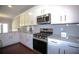 Bright kitchen featuring granite countertops, stainless steel appliances, and white cabinetry at 2304 Shetley Creek Dr, Norcross, GA 30071