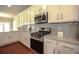 Well-lit kitchen featuring white cabinetry, granite countertops, and stainless steel appliances at 2304 Shetley Creek Dr, Norcross, GA 30071