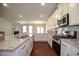 Open kitchen with granite countertops, stainless appliances, and view into the living room at 2304 Shetley Creek Dr, Norcross, GA 30071