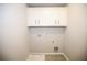 This laundry room has overhead storage cabinets and tile flooring at 2304 Shetley Creek Dr, Norcross, GA 30071