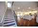 Bright, open-concept living space with hardwood floors, staircase, and kitchen with stainless steel appliances at 2304 Shetley Creek Dr, Norcross, GA 30071