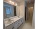 Bright bathroom featuring a double vanity and a large mirror reflecting natural light from a window at 2840 Alcovy River Vw, Dacula, GA 30019