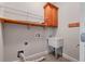 Functional laundry room featuring a utility sink, upper cabinet and shelving for storage at 300 Towne Overlook Cir, Canton, GA 30114