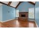 Cozy living room showcasing a brick fireplace, hardwood floors, wooden beam accents, and natural light at 300 Towne Overlook Cir, Canton, GA 30114