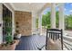 Charming front porch with stone wall, white pillars, rocking chair, and outdoor plants creating a cozy space at 3903 Hazelhurst Dr, Marietta, GA 30066
