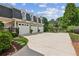 Exterior view of a home's garage with three bays, neutral siding, black roof, and spacious parking area at 3903 Hazelhurst Dr, Marietta, GA 30066