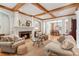 Open-concept living room with hardwood floors, fireplace, wood beams, and access to the dining area at 3903 Hazelhurst Dr, Marietta, GA 30066