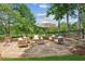 Charming stone patio area with comfortable seating, an umbrella, and a fire pit, set in a beautifully landscaped yard at 3903 Hazelhurst Dr, Marietta, GA 30066