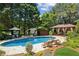 Lounge chairs and umbrellas surround the in-ground pool and spa with outdoor dining in the background at 3903 Hazelhurst Dr, Marietta, GA 30066