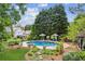 A bird's eye view of an in-ground pool with spa, lounge chairs, umbrellas, and lavish landscaping at 3903 Hazelhurst Dr, Marietta, GA 30066
