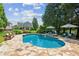 A backyard in-ground pool features flagstone decking, seating, lounge chairs, and lush surrounding landscaping at 3903 Hazelhurst Dr, Marietta, GA 30066