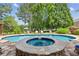 A backyard in-ground pool and hot tub are surrounded by stone, lounge chairs, and professional landscaping at 3903 Hazelhurst Dr, Marietta, GA 30066