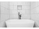 Freestanding white tub with modern hardware and sleek white marble tiled walls at 1090 Mcdaniel St, Atlanta, GA 30310