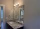 Stylish bathroom vanity featuring granite countertops, decorative lighting and a large mirror at 339 Morgan Se Pl, Atlanta, GA 30317
