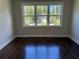 Bright bedroom features dark hardwood floors and a large window with a view of the outside at 339 Morgan Se Pl, Atlanta, GA 30317