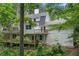 Back exterior view of a multi-story home with multiple decks surrounded by greenery at 4018 Dunbarton Ne Way, Roswell, GA 30075
